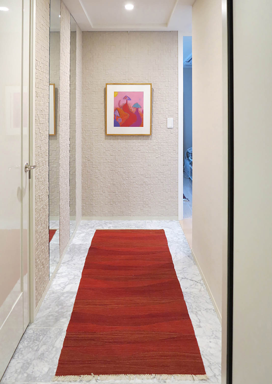 白の床の上に敷かれる赤のキリムランナーの写真