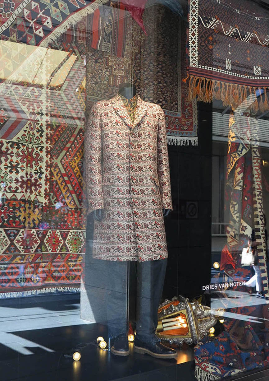 ウィンドウに展示されるブラウン系のアンティークキリムと服の写真